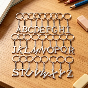 Polished silver metal alphabet keychain set A-Z on a textured wooden background