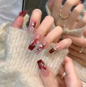 Close-up of long coffin press-on nails with 3D red roses, pearls and rhinestones