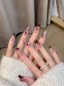 Detailed macro view of coffin nails with 3D red roses pearls and rhinestones on deep red