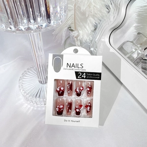 Macro view of gradient red press-on nails with 3D floral accents and pearl details