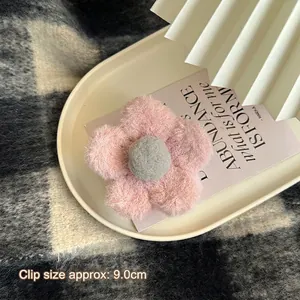 Détail de la pince à cheveux fleur en peluche de 9cm avec pétales roses et centre gris