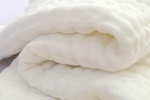 Close-up of soft white crinkle gauze cotton fabric with thick honeycomb texture