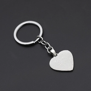 Detail shot of heart pendant keychain with dotted embossed texture and silver finish