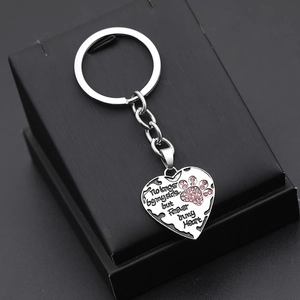 Silver heart keychain with pink rhinestone paw print and memorial text on black box