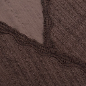 Détail du décolleté en V avec bordure en dentelle élégante sur maille côtelée marron