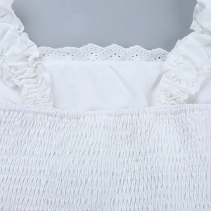 Detail of square neckline with eyelet lace embroidery and smocked bodice texture