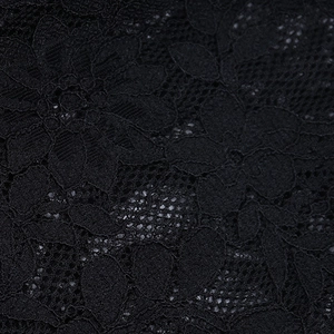 Detailed close-up of intricate black lace fabric with hollow-out floral pattern and texture