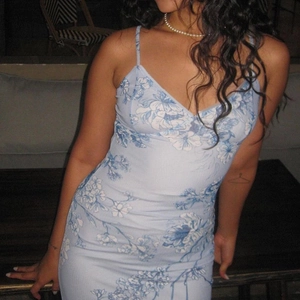 Close-up of light blue A-line dress with large dark blue floral print and slim straps