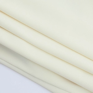 Gros plan du tissu en maille crème montrant la texture douce et le tissage du haut court