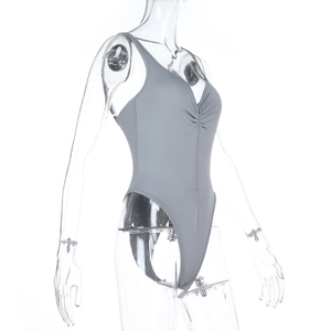 Detail of grey bodysuit with deep V-neck, ruched front chest and high cut leg design