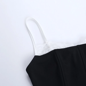 Detail of black camisole featuring white lace trim and slim shoulder straps