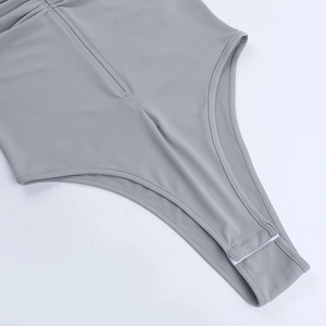 Detail view of the gray bodysuit showing smooth fabric texture and bottom snap buttons