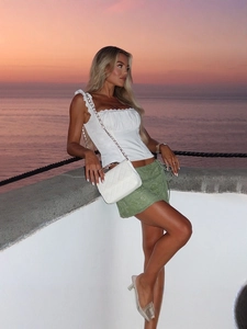 Chic summer outfit with white ruffled tank top and green side-tie embroidered skirt