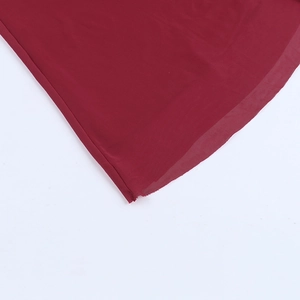 Detailed macro shot of the burgundy mesh hemline and fine stitching on the A-line dress