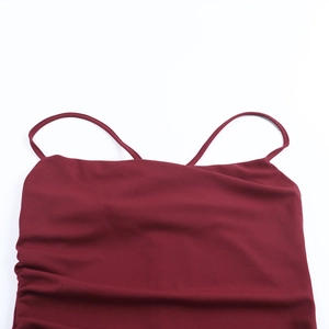 Detail of burgundy strapless dress featuring thin straps and elegant side pleating textures