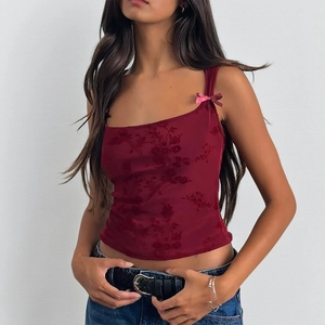 Detail of burgundy sleeveless top featuring flocked rose patterns and a pink satin bow accent