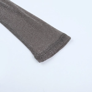 Macro shot of silver sparkling knit fabric and flat-stitched cuff detail of the dress