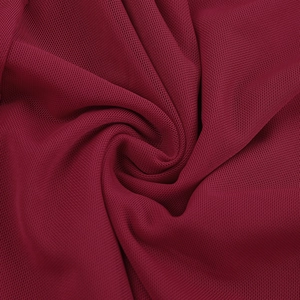 Macro shot of burgundy mesh fabric texture with soft drape and refined micro-hole structure