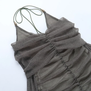 Detailed view of ruched dark grey-green fabric with sparkling metallic texture and beads