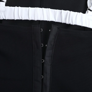 Detailed macro view of silver metal hook-and-eye closures on black mesh fabric top