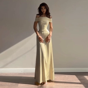 Detail of elegant off-shoulder champagne satin evening gown with pleated neckline and slim waist