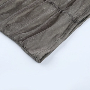 Detailed macro view of the dark grey shimmering metallic fabric with pleated texture