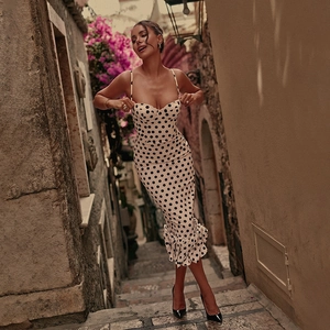 Close-up of elegant white polka dot dress featuring a sweetheart neckline and ruffled hem
