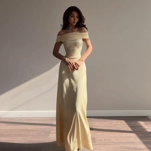 Detail of light yellow off-shoulder gown with elegant silk sheen and flared skirt