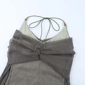 Detail of glittery fabric texture and gold bead accents on the halter strap neckline