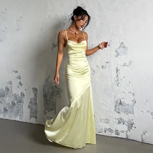 Detail of light yellow satin dress featuring a draped cowl neck and silky fishtail silhouette