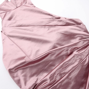 Detail of dusky pink satin dress with pleated texture and shimmering fabric finish