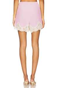 Detail of light pink high waist shorts with delicate white floral lace hem and elastic waist