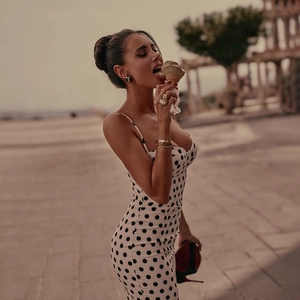 Detail of slim-fit polka dot dress paired with vintage gem ring and golden jewelry set