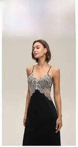 Detailed view of black satin nightgown featuring white floral lace patchwork on chest