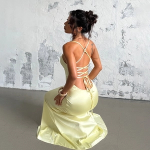 Detail of cross-back straps and silky pale yellow satin texture on the backless dress