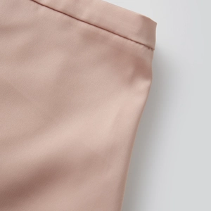 Detailed close-up of light pink lace shorts featuring premium twill fabric and refined waistband
