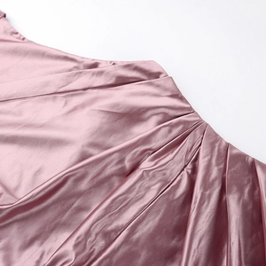Detail of pink satin fabric with elegant pleated folds and smooth glossy texture