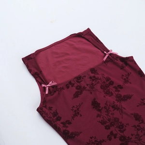 Close-up of burgundy floral velvet camisole with delicate pink silk bow shoulder details