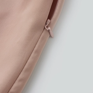 Detail of pink wide-leg shorts featuring a smooth hidden zipper and fine fabric texture