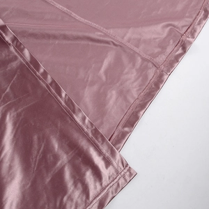 Detail of shimmering pink satin fabric with high-quality stitching and mesh lining