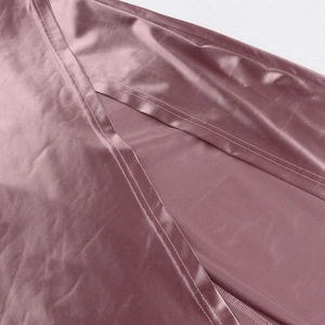 Detailed macro shot of the side slit and satin texture on a pink off-shoulder dress