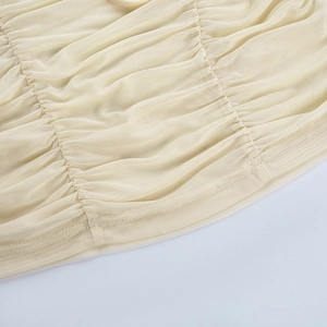 Detail of light beige mesh fabric showing delicate ruched texture and soft material