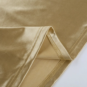 Detailed view of glossy gold fabric with precise stitching and metallic sheen