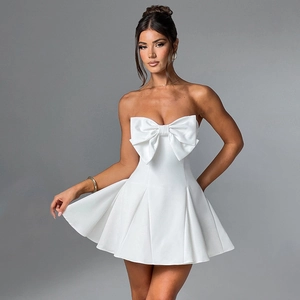 Detail view of white strapless mini dress featuring a large oversized front bow and pleated skirt