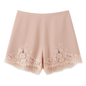 Detail of delicate lace trim and eyelash edges on high-waist dusty pink shorts
