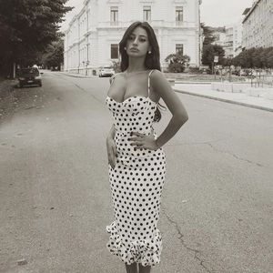 Detailed close-up of retro polka dot print dress with ruffle fishtail hem and slim fit