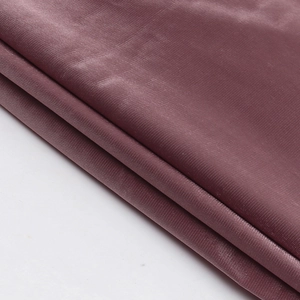 Detailed macro view of dark purple shimmering silk fabric with fine woven texture and soft folds