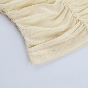 Detail of hollow-out mesh fabric with gathered pleats and clean double-needle stitching