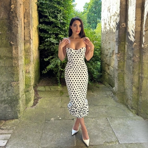 Detail of white polka dot dress with heart-shaped neckline and slim spaghetti straps