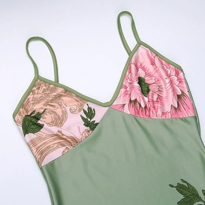 Detail of olive green satin dress featuring retro floral print and thin straps